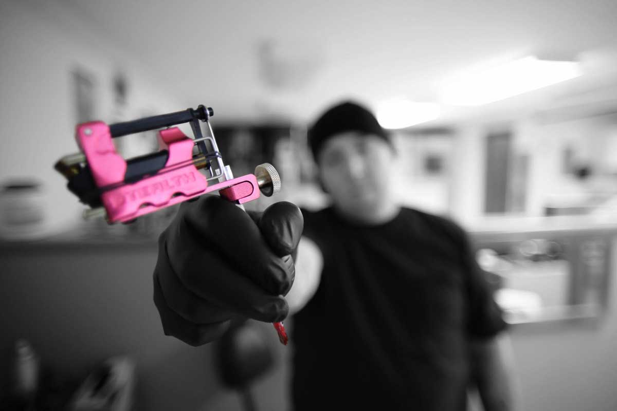 Connecticut tattoo artist holding a pink tattoo gun
